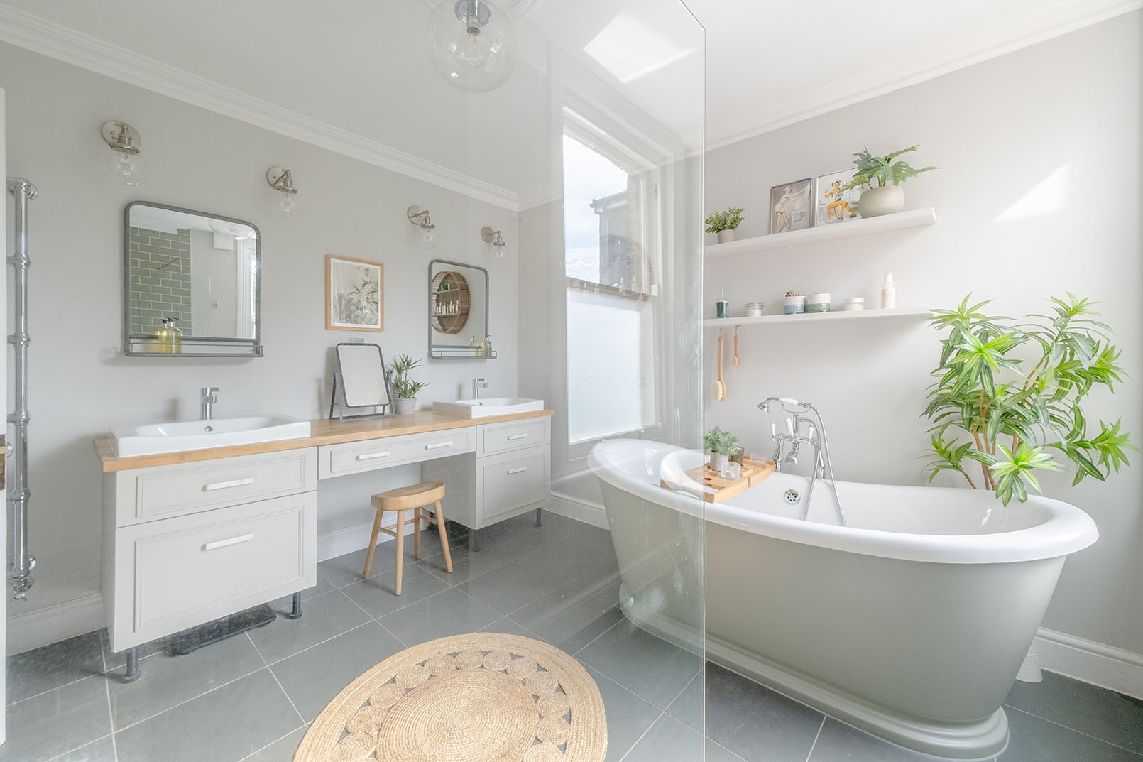 a bathroom photo from a property photography series, natural colours, bright and modern design space, light grey walls, a double sink counter with wooden material, a bathtub is seen behind a shower screen