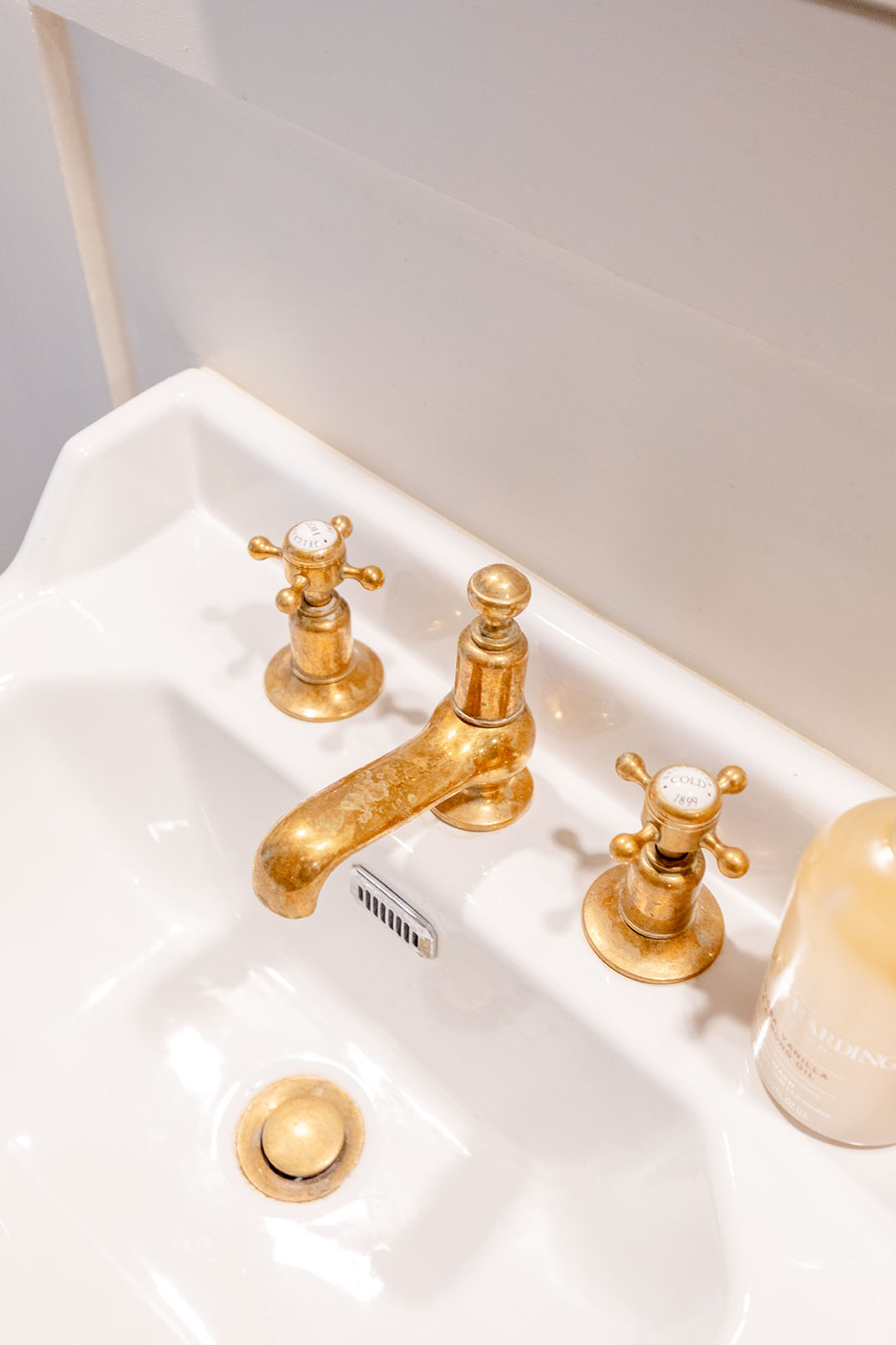 high angle view of a vanity unit with bronze gold coloured taps.