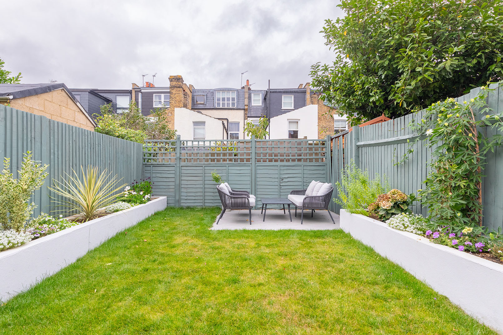 a large garden with a seating group at the end, captured for property photography.