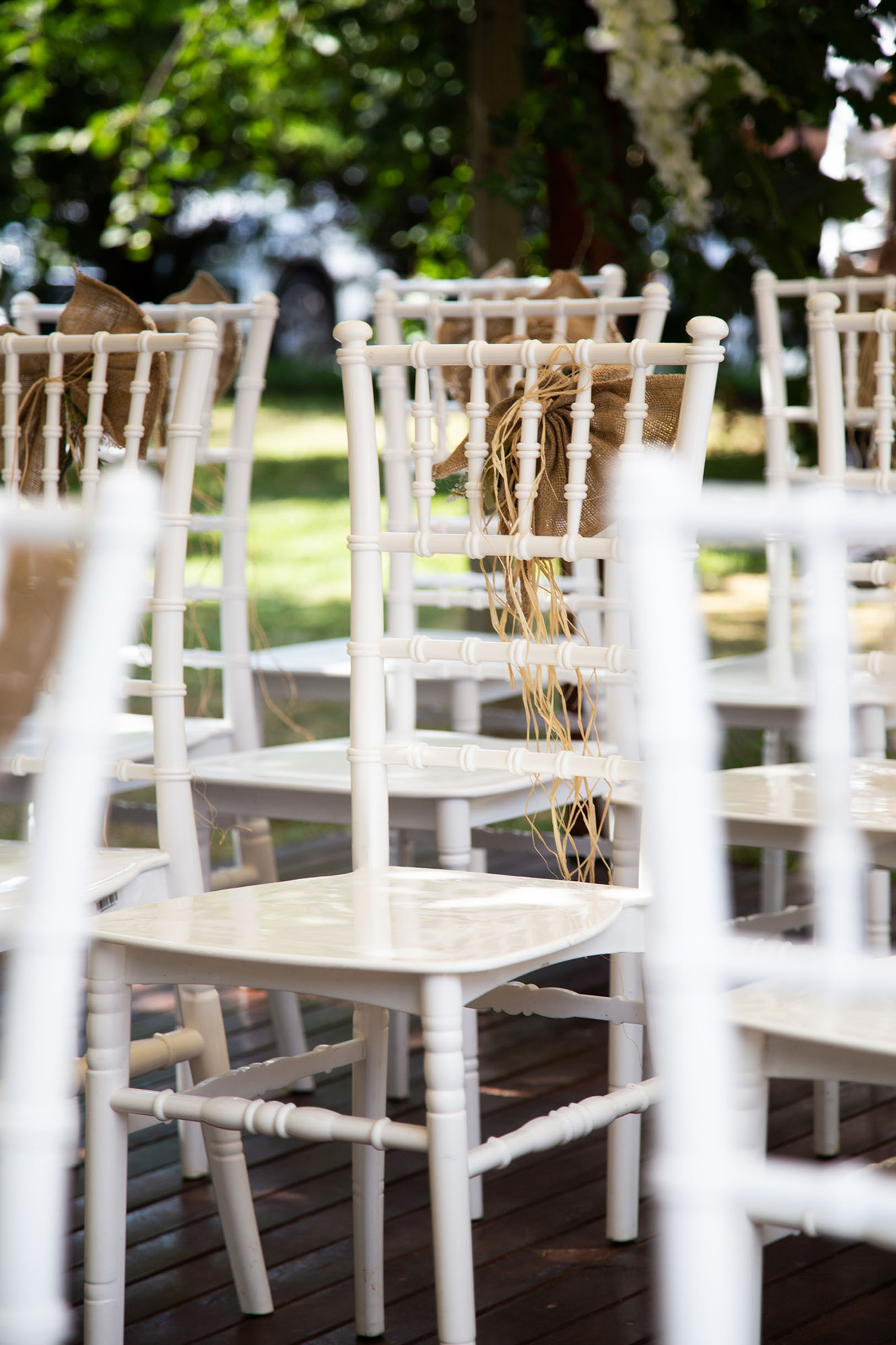wedding photo of a seating area with white wooden chairs.